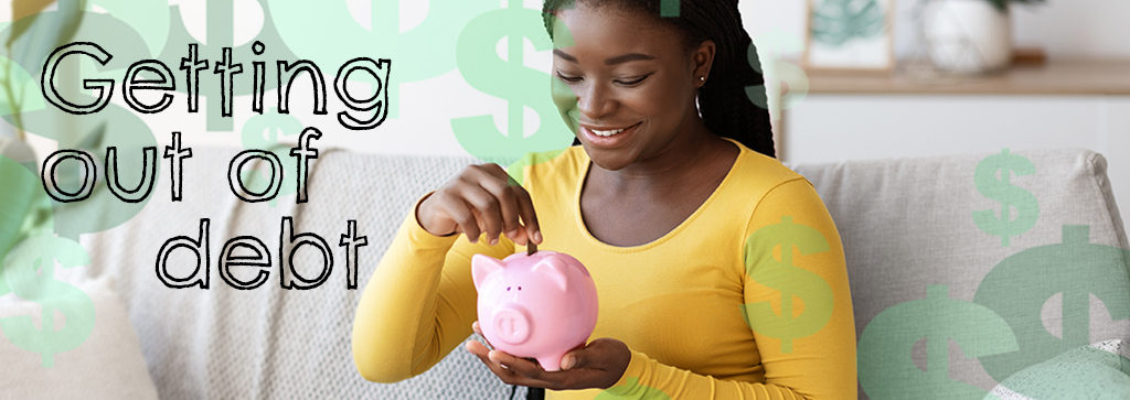 Woman smiling while putting change into a piggy bank